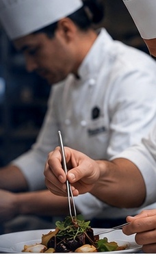 Professional chef preparing a plated dish
